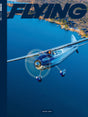Cover of 'Flying' magazine with a blue airplane flying over water and land.