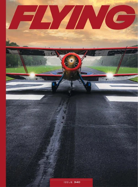 Red airplane on a runway with 'FLYING' magazine cover